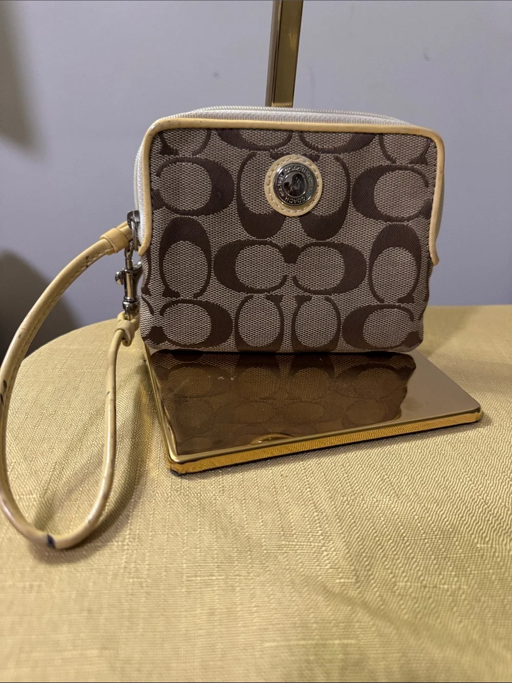 This is a Coach Poppy Signature Wristlet featuring the iconic C pattern